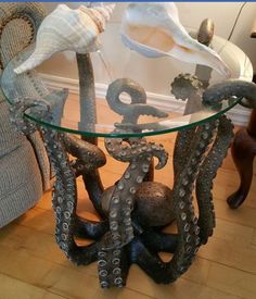 an octopus table with glass top and metal legs