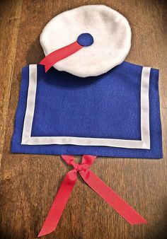 a blue and white cloth with a red ribbon around it on top of a wooden table