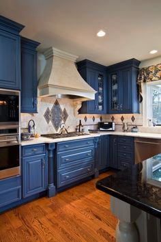 a kitchen with blue cabinets and wood floors