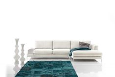 a white couch sitting on top of a blue rug