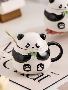 a panda bear tea cup sitting on top of a table