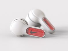 two white ear buds with red and black logos on the side, one is plugged in