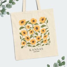 This cute Kansas floral tote bag features Kansas's state flower, the 'wild sunflower', making it perfect for use as a shopping tote for farmers' market hauls, the beach, school, books, library, or everyday adventures. The sturdy construction ensures it can handle your essentials with ease. Customize or personalize it to give as a bridesmaid gift, bachelorette gift, or teacher gift. With our 'original' hand-drawn floral art, this floral cotton canvas tote bag becomes a great memento of the places Everyday Sunflower Design Tote Bag, Everyday Sunflower Tote Bag, Paint Canvas Bag, Tote Bag Decoration, Sunflower Making, Kansas State Flower, Kansas Travel, Sunflower Tote Bag, Painted Tote Bag