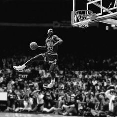 an old photo of a basketball player in the air