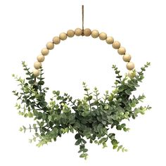 a wooden beaded wreath with green leaves and berries hanging from it's side