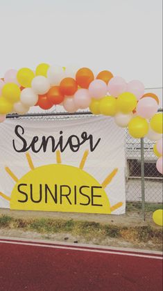 a sign that says senior sunrise with balloons in the shape of a sun on it