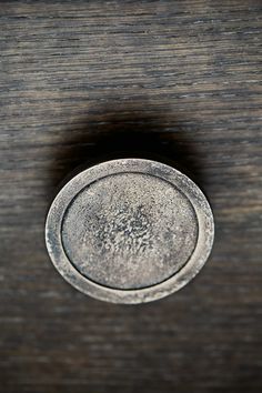 an old metal object sitting on top of a wooden table