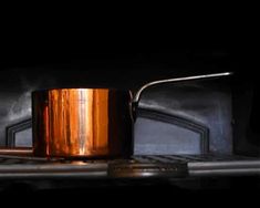 a copper mug sitting on top of a stove