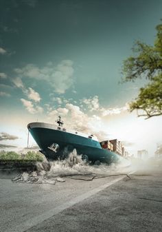 a large blue boat on top of a body of water next to a tree and sky