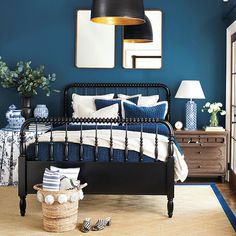 a bed room with a neatly made bed and blue walls