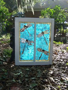 a stained glass window with dragonflies on it