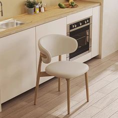 a white chair sitting in front of a kitchen counter next to a stove top oven