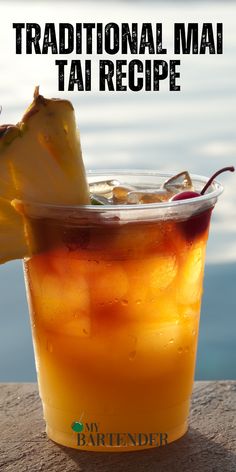 a drink in a plastic cup sitting on top of a table next to the ocean