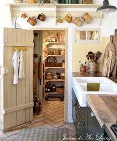 an open kitchen door with pots and pans on the shelves