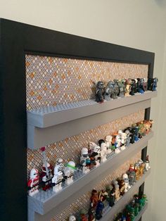 lego star wars toys are lined up on the wall in this display case for sale