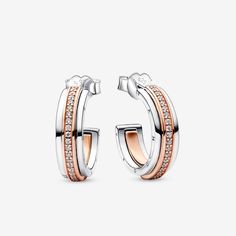 Create your signature ear stack with the Pandora Signature Two-tone Logo & Pavé Hoop Earrings. These earrings feature a detailed two-tone square profile. The slightly raised 14k rose gold-plated design runs throughout the center middle parts, embellished with a central row of sparkle. The sides of the hoop earrings are engraved with the Pandora logo. A staple for any jewelry collection, this elevated pair of hoops stands out on its own or in a perfectly curated ear stack. - Pandora Signature Two tone Logo & Pavé Hoop Earrings - Sterling silver and 14k Rose gold-plated unique metal blend / Cubic Zirconia / Clear Types Of Earrings, Moon Studs, Classic Earrings, Shell Earrings, Heart Studs, Accessories Jewelry Earrings, Heart Earrings Studs, 925 Sterling Silver Earrings, Cute Earrings