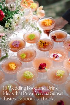 a table topped with lots of glasses filled with drinks and flowers on top of it