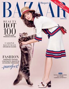 a woman is holding a cat on the cover of bazaar