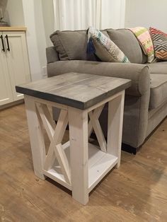 a living room with a gray couch and wooden table