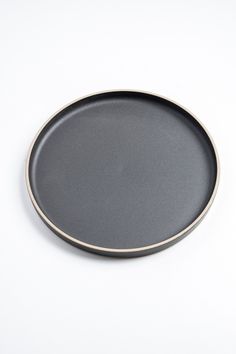 a black plate sitting on top of a white table