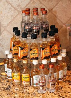 many bottles of liquor are stacked on top of each other in front of a marble countertop