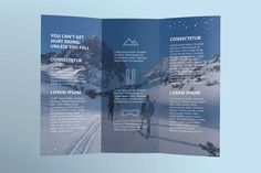 an open brochure with two people walking in the snow and mountains behind them