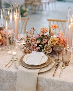 the table is set with flowers and candles