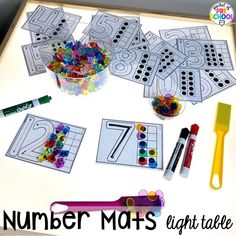 a table topped with lots of crafting supplies and numbers for kids to use on their crafts