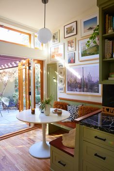 a room with pictures on the wall and a table in front of an open door