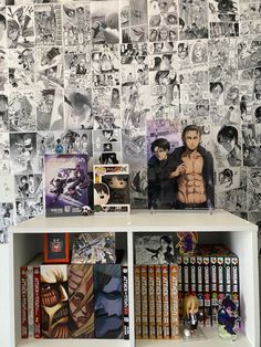 a book shelf filled with books next to a wall covered in anime pictures and comics