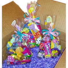 a box filled with lots of candy and candies on top of purple shredded paper