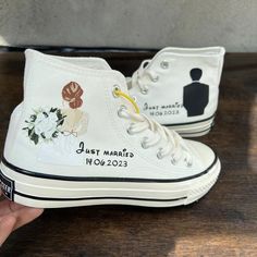 someone is holding their wedding converses with the bride and groom's names on them