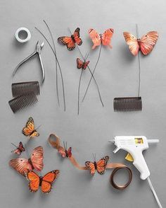 butterflies, combs and scissors are arranged on a gray surface with the hairdryer in the foreground