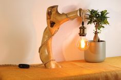 a lamp that is sitting on top of a table next to a potted plant