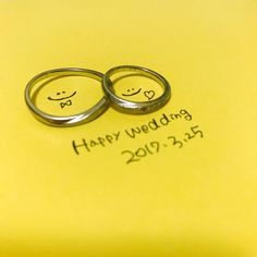 two wedding rings sitting on top of a yellow post - it note that says happy wedding