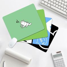 three square coasters on top of a desk next to a keyboard and calculator