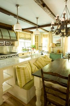 a kitchen with an island, stove and dining room table in it's center