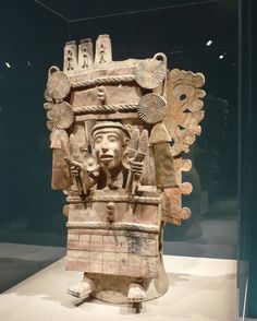 an ancient statue is on display in a glass case