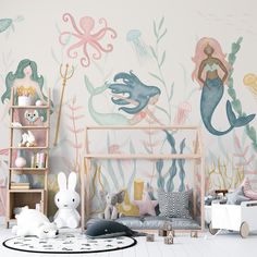 a child's room with mermaid themed wallpaper and toys in the foreground