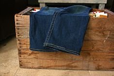 a pair of jeans are sitting in a wooden crate