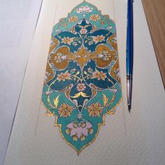 a pen sitting on top of a piece of paper next to a drawing pad with an ornate design