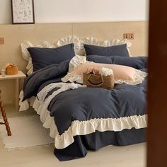 a bed with blue and white ruffled bedspread, pillows and pillow cases