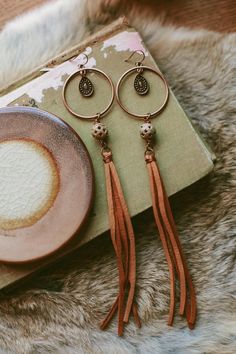 a pair of feminine deerskin leather tassel earrings with boho copper findings + beads. Hung on brass wires. Bohemian Copper Beaded Earrings, Bohemian Copper Dangle Hoop Earrings, Bohemian Copper Earrings With Dangling Beads, Nickel-free Copper Beaded Bohemian Earrings, Bohemian Rust-colored Nickel-free Earrings, Leather Tassel Earrings, Deer Skin, Leather Tassel, Boho Look