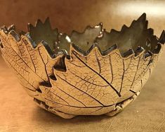 a leaf shaped bowl sitting on top of a table