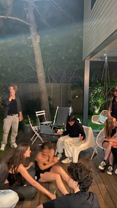 a group of people sitting on top of a wooden deck