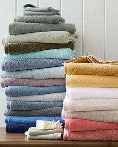 a stack of folded towels sitting on top of a wooden table