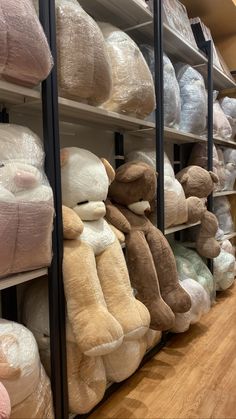 many stuffed animals are stacked on shelves in a room with wooden floors and hard wood flooring