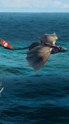 a large bird flying over the ocean