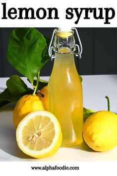 lemon syrup in a glass bottle next to sliced lemons