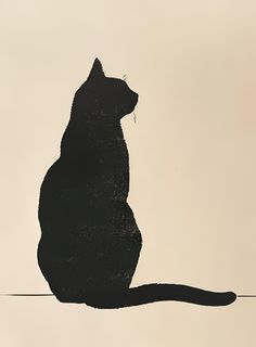 a black cat sitting on top of a white surface